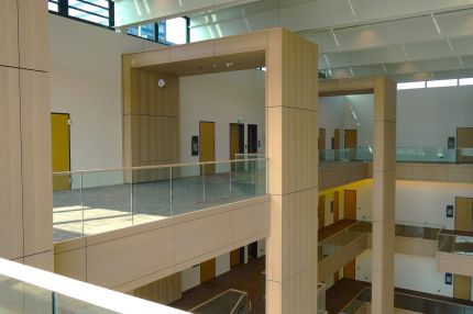 Galerie mit holzverkleidetem Rahmen und Glasbrüstung im Obergeschoss – Justizzentrum Bochum
