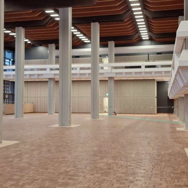 Speisesaal mit Stützen, Holzkassettendecke, Galerie und Treppe – Mensa Würzburg
