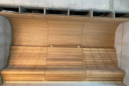 Sitznische mit Holzbank und gerundeter Verkleidung aus Eichen-Schlitzplatten – Technisches Rathaus Mannheim