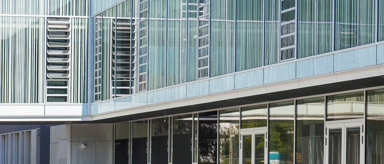 Glasfassade mit vertikalen Lamellen und verglaster Eingangsfront am Innenhof – Gymnasium Oberursel