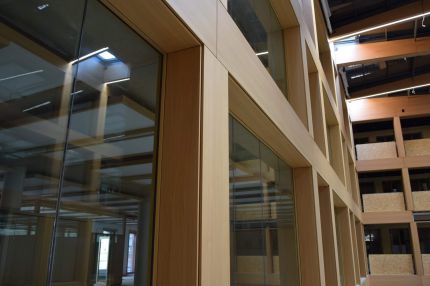 Blick entlang der holzfurnierten Fensterfront nach oben zu den Dachträgern – IHK Nürnberg