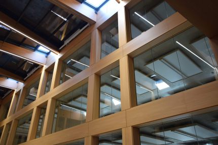 Blick nach oben auf das holzfurnierte Fassadenraster und die Oberlichter im Atrium – IHK Nürnberg