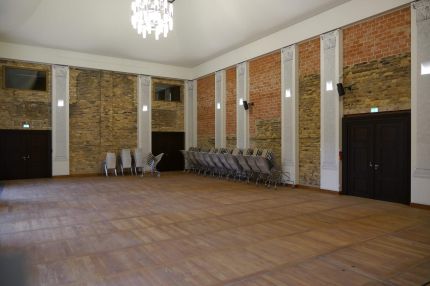Festsaal mit Sichtmauerwerk, Pilastern, Kronleuchter und Parkett – Neues Schloss Bad Muskau